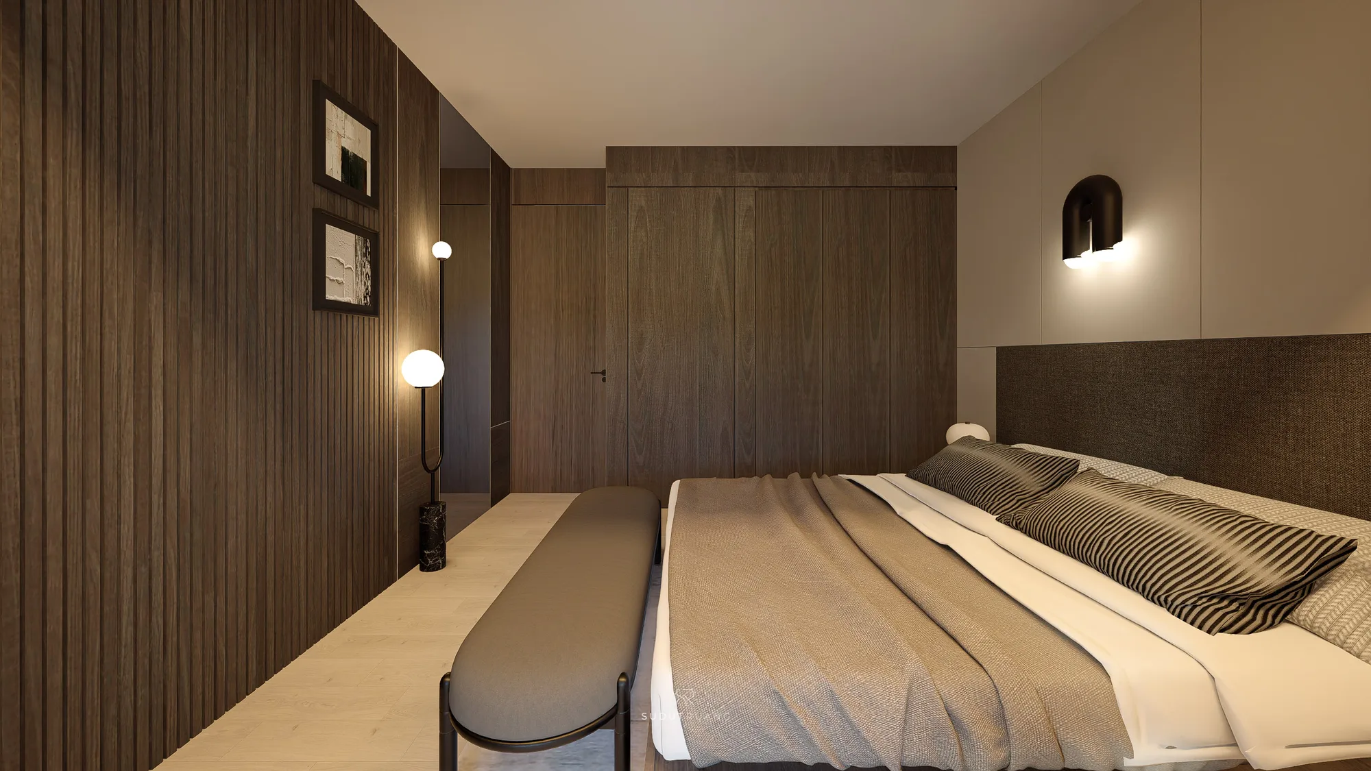 Bedroom's fluted timber wall holds two framed prints beside a floor lamp, facing a full-height wardrobe finished in matching walnut panelling.