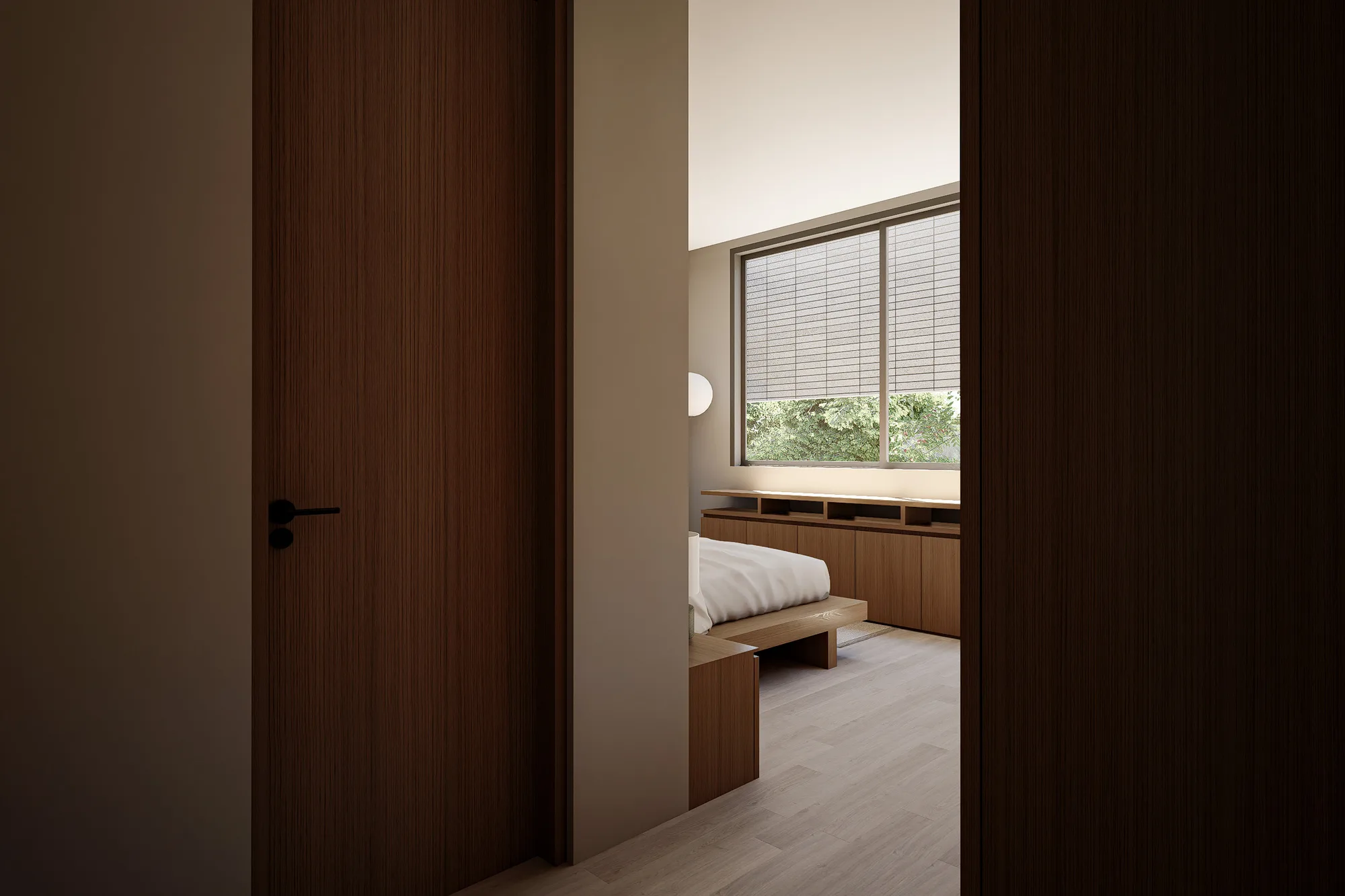 Through an open door, a bedroom's low bed and window bench catch afternoon light behind a woven shade.