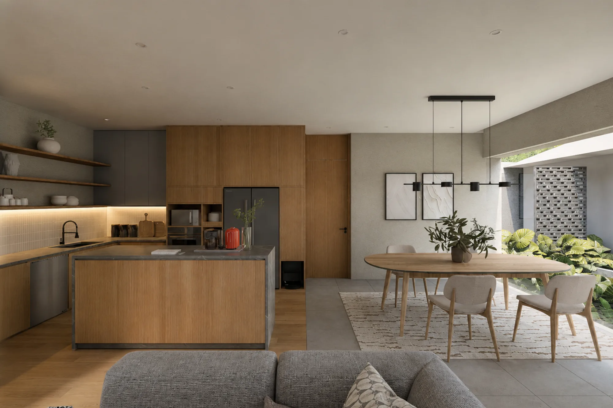 Oval dining table set beneath a black linear pendant, framed prints and a perforated brick panel visible on the wall behind.