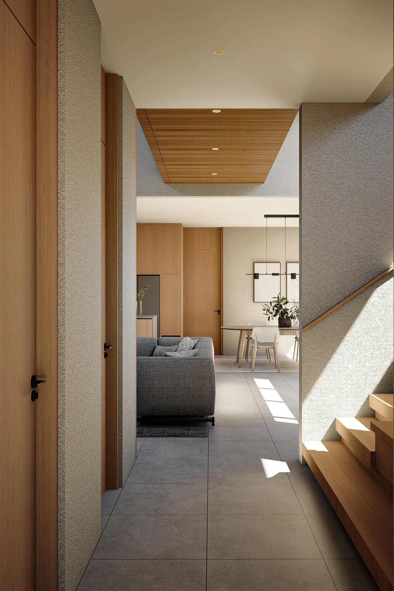 View down the stair landing toward the open living and dining area, sunlight cutting across the tiled floor.