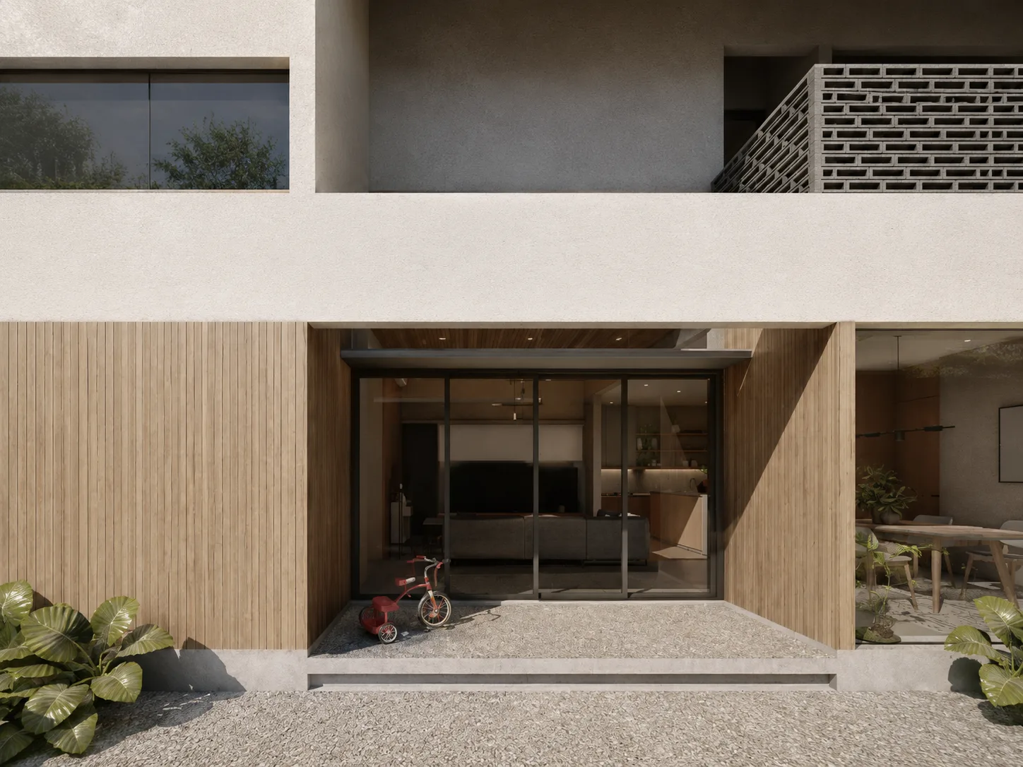 Timber-clad facade with a full-height glass door opening the living room to a gravel courtyard, a child's tricycle parked just inside.