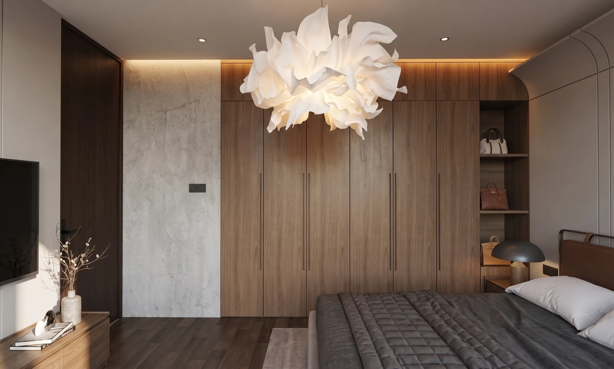A full-height walnut wardrobe wall anchors this bedroom, a ruffled white pendant hanging above the dark wood floor between a wall-mounted television and open display shelving.