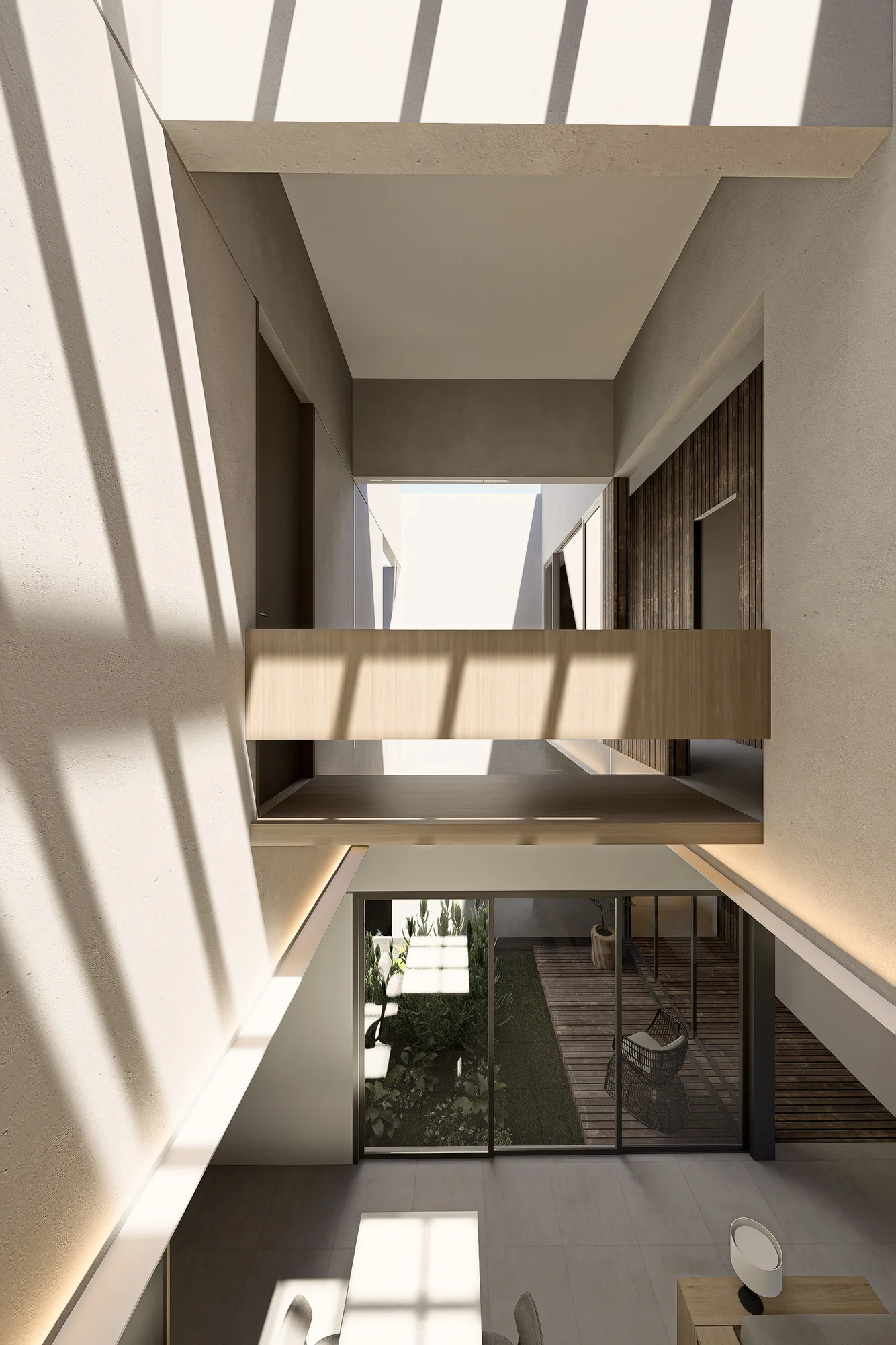 Double-height void looking down through the stair opening onto a rattan chair and the courtyard deck below.