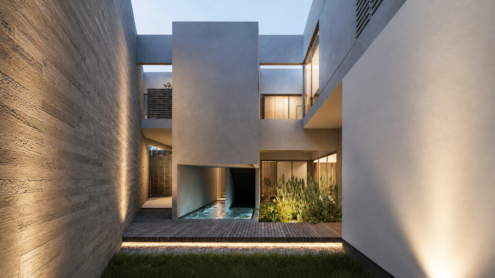 Kebagusan House's central courtyard at dusk: a board-marked concrete wall lit from below, a raised white mass over a narrow reflecting pool, timber decking and planting beside glazed rooms.