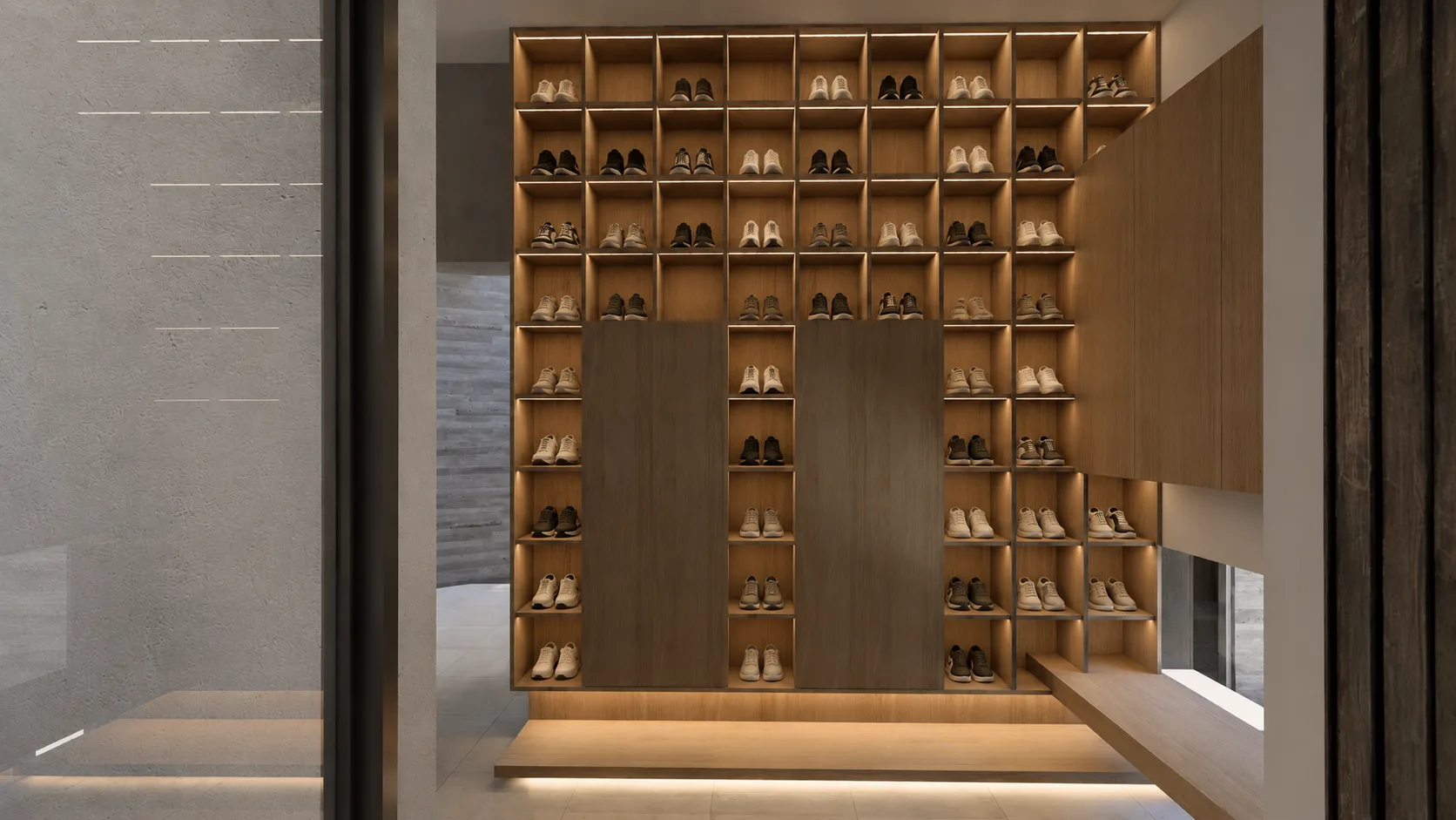 Backlit shoe wall with rows of open oak cubbies interspersed with closed cabinet panels.