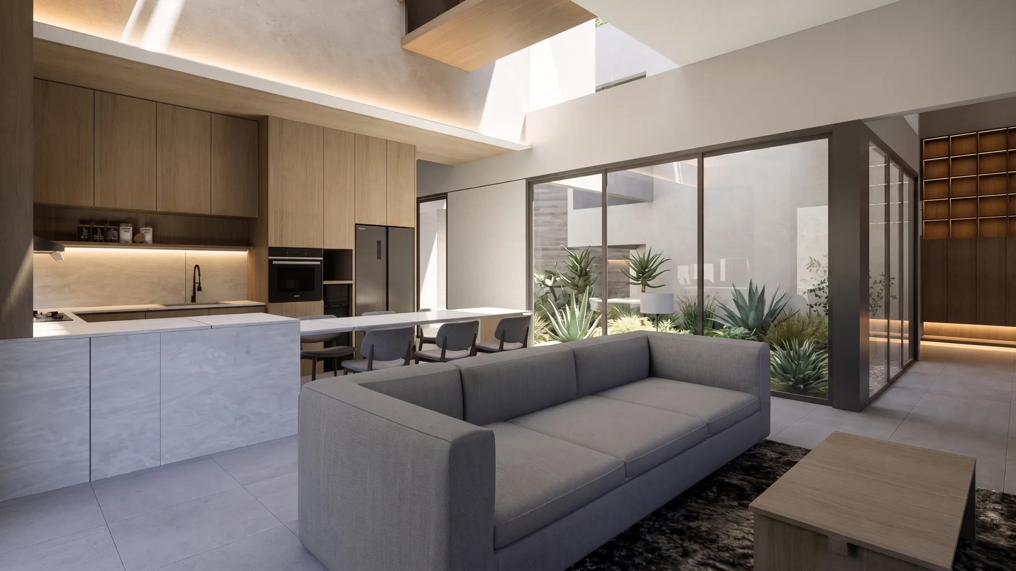 Open-plan living room with a grey sectional sofa facing a courtyard of agave and cacti through full-height glazing.
