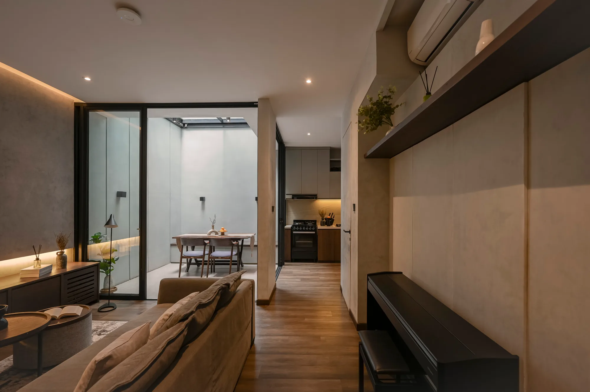 Living room framed by a structural column, looking through to the dining area and kitchen beyond.