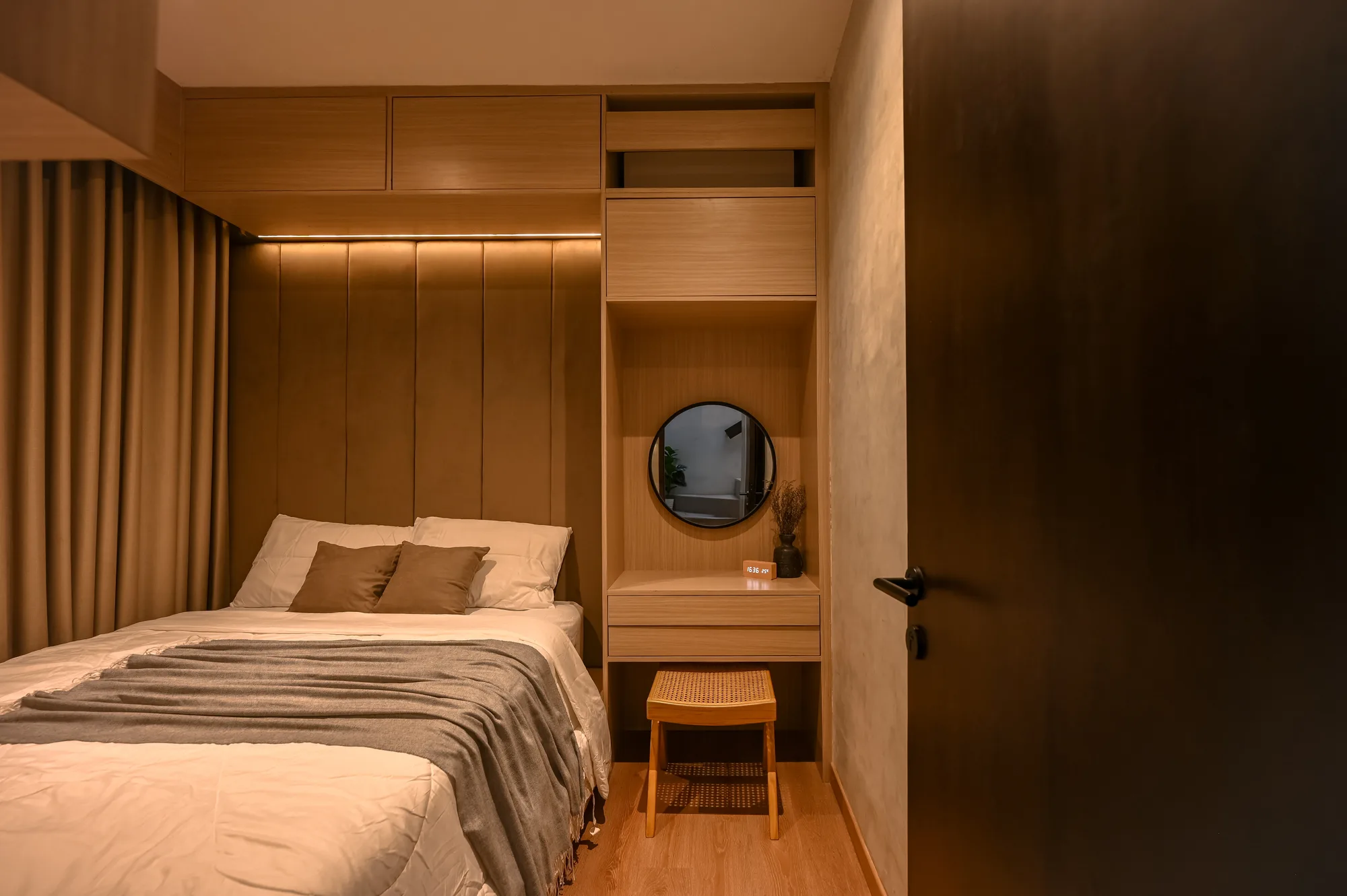 Bedroom built-in cabinetry with a round mirror niche above a channel-tufted headboard.