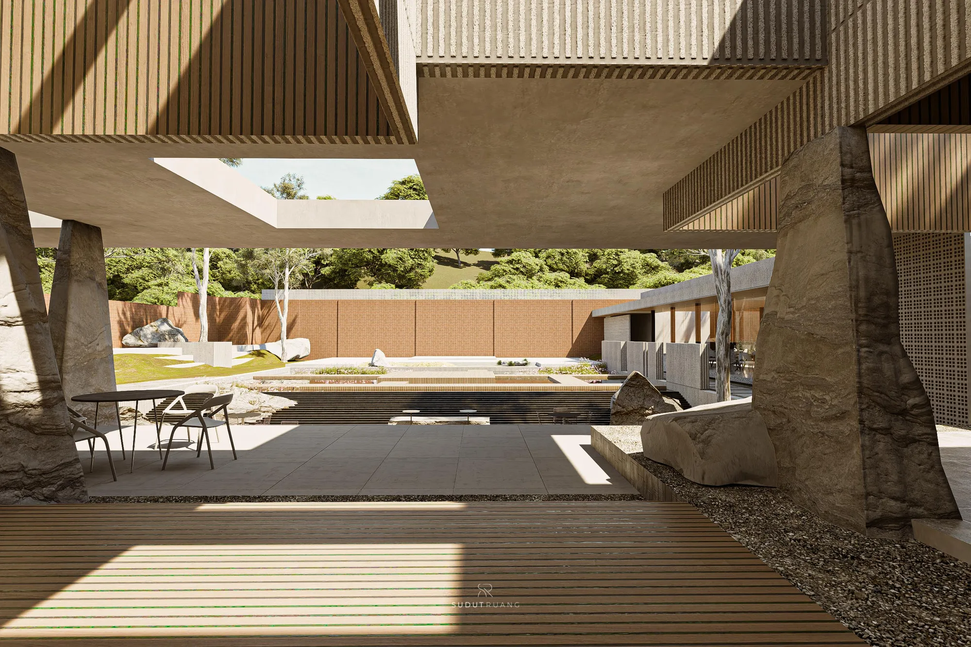 A paved walkway beside a textured screen wall, boulders set along its edge.