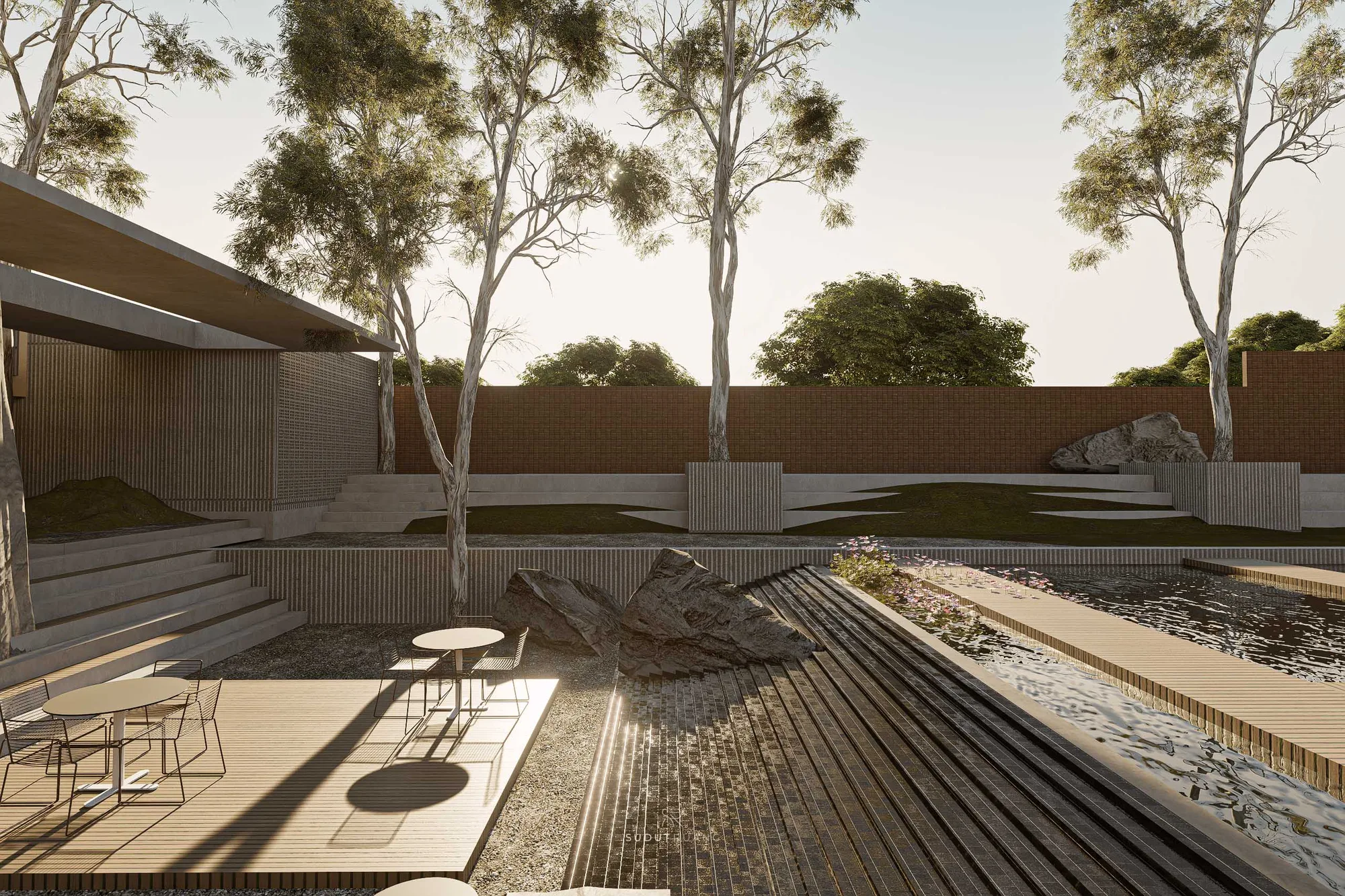 The reflecting pool and wildflower border at dusk, garden mounds rising beyond the brick boundary wall.
