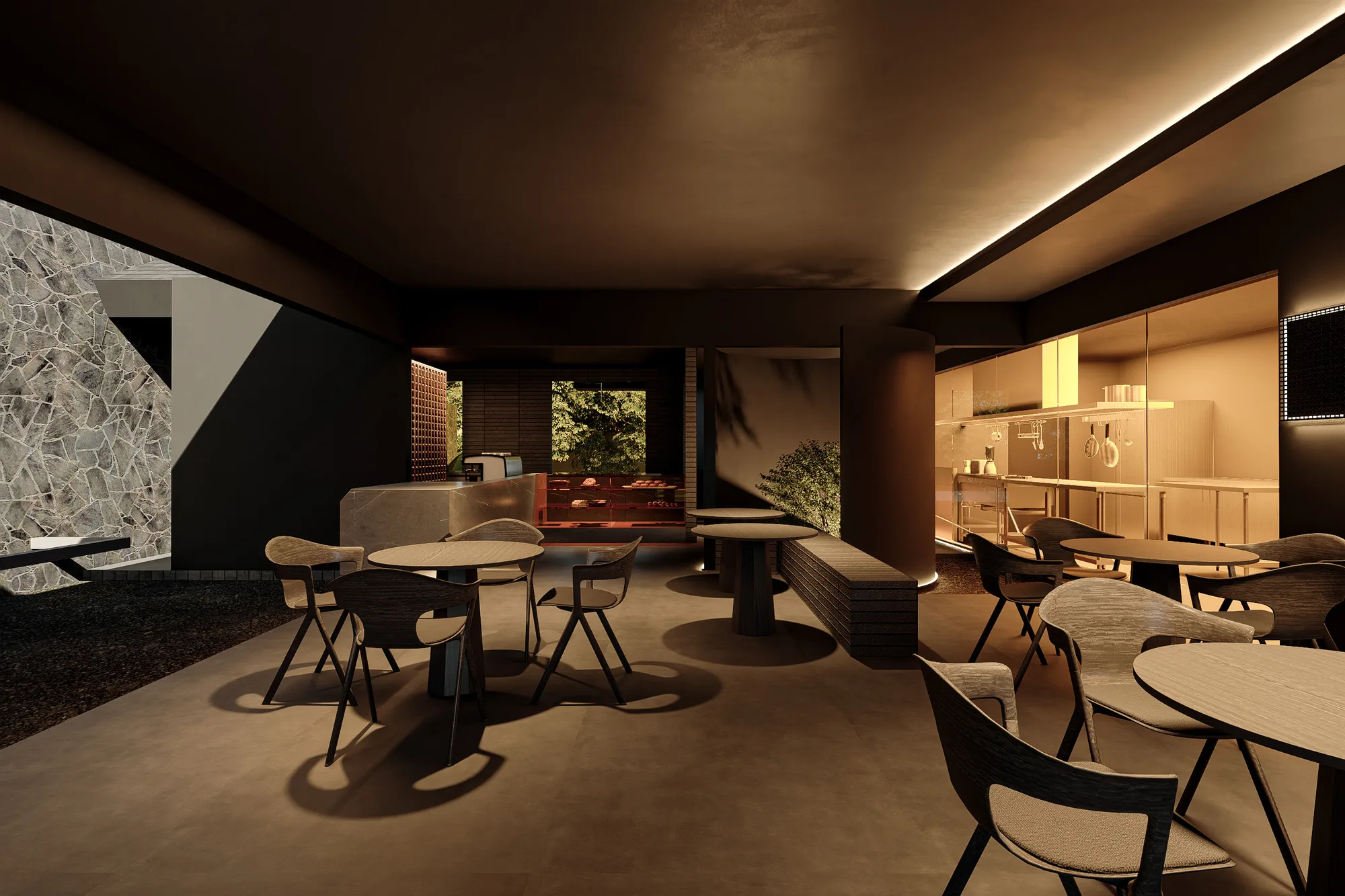 Dining lounge with round tables, a stone wall on one side and the glass-fronted kitchen on the other.