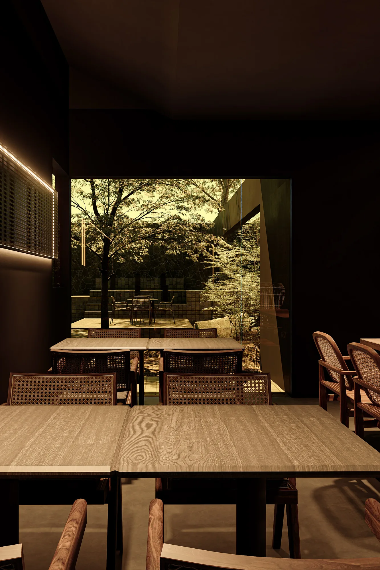 The dining room in cane chairs and wood tables, its glass wall opening onto the tiled courtyard.