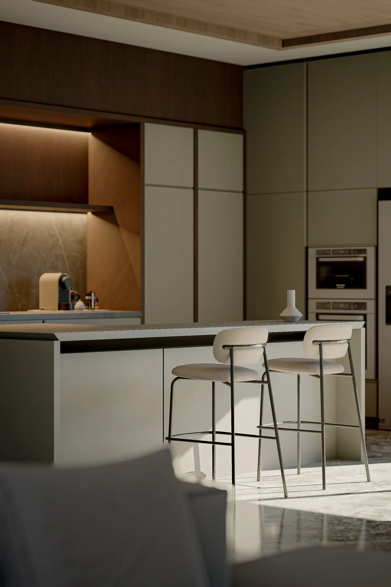 Kitchen island detail with bar stools beside a recessed backlit shelf and built-in oven and refrigerator.