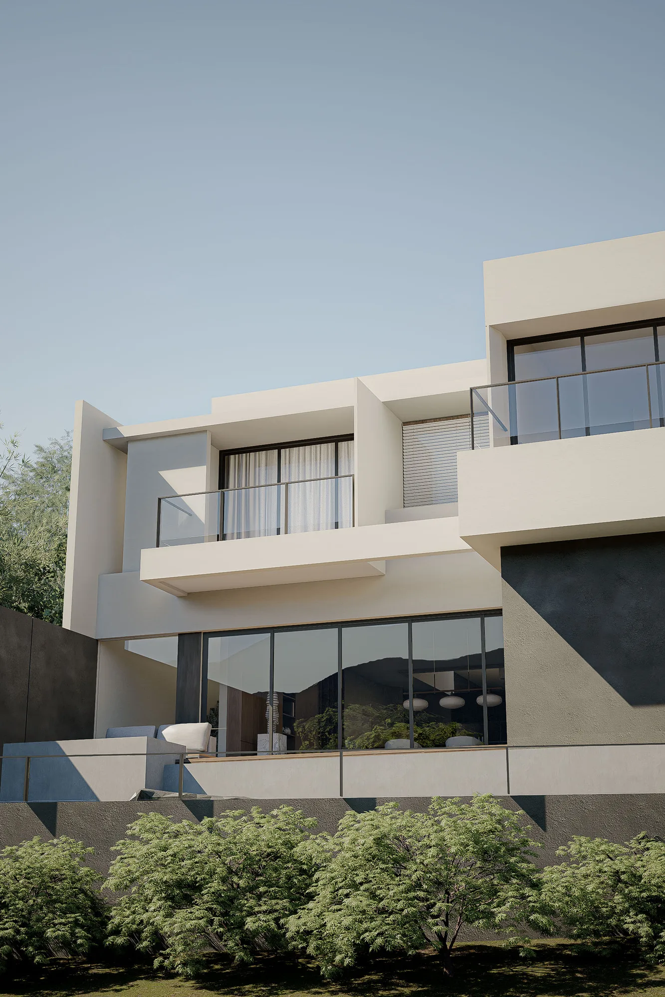 Upper facade detail of layered white volumes and glass balustrades against a clear sky, bamboo screening the boundary wall.